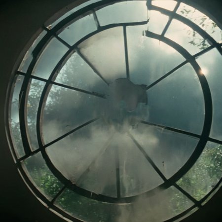Horror-themed,  <lora:Fright Night 1985 Film Style:1>
Cinematic low angle Closeup Shot Film Footage captured by Panavision Cameras and Lenses a circular broken window stain with a foggy sky view in a background with perfect warm sunlight shaft light ray light coming through, Fright Night 1985 Film Style, Eerie, unsettling, dark, spooky, suspenseful, grim, highly detailed
