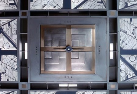 *A futuristic, cubic room where every surface—the floor, walls, and ceiling—looks identical, creating a symmetrical and disorienting space. The room is made of metallic panels, each featuring intricate, geometric patterns resembling advanced circuitry. These patterns are precisely cut into the metal, allowing a soft, white light to filter through, casting sharp, complex shadows across the surfaces. The cold, white light gives the room a sterile, almost otherworldly feel. The metallic surfaces subtly reflect the light and patterns, amplifying the sense of depth and making it difficult to distinguish one wall from another.
In the center of each of the six surfaces, including the floor and ceiling, is a square metallic door, seamlessly integrated into the surrounding panels. These doors are identical and blend into the room’s design, adding to the disorienting and claustrophobic atmosphere. The uniformity and symmetry of the room create a high-tech, sterile environment that feels isolating and mysterious.
The overall ambiance is one of eerie sophistication, blending advanced technology with unsettling uniformity. The space feels like a confining, enigmatic environment where every direction is the same, leaving anyone inside with a sense of isolation and uncertainty. Each surface of the room looks exactly the same. The room is 5 meters long in each direction.*