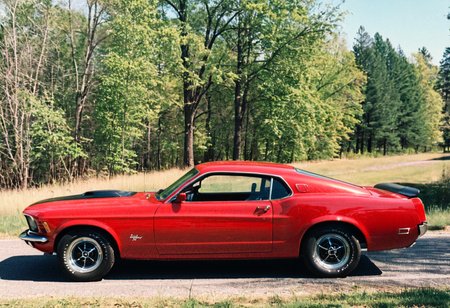 ClassicMuscleCar, red Ford Mustang, side view, sunny, road, vegetation, trees, 4K, highly detailed, (stylish grainy analog 35mm film photo, "BUZZ")
