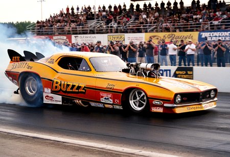 VintageMuscleCar, dragster, side view, race track, smoke trail, people, outdoors, 4K, highly detailed, (stylish grainy analog 35mm film photo, "BUZZ")