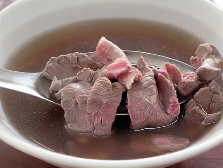 A high-resolution, hyper-realistic image of a bowl of Sweetbeefsoup. This traditional dish features a clear, sweet broth that is the star of the dish. The broth is simmered to perfection, with a hint of sweetness that tantalizes the taste buds. A subtle hint of pink is added to the broth, giving it a unique and appealing look. It's served in a traditional ceramic bowl, placed on a rustic wooden table. The scene is set in a cozy kitchen, with all elements in sharp focus, creating a clear and detailed image. The lighting should be warm and inviting, highlighting the appetizing qualities of the Sweetbeefsoup and the homely atmosphere of the setting, <lora:beefsoup:0.8>