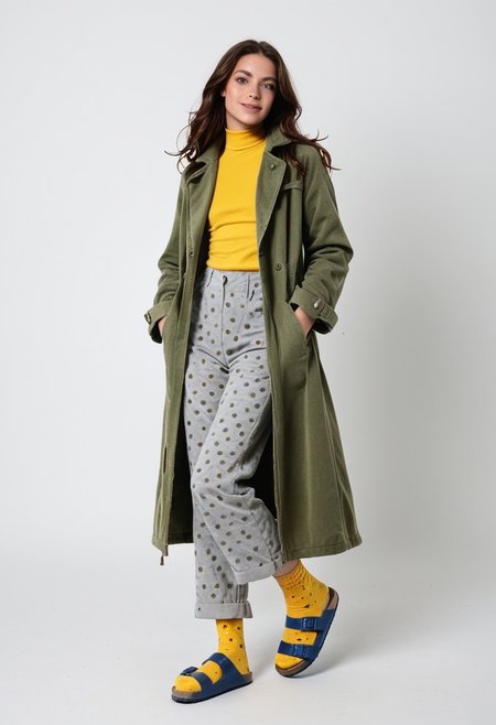 (realistic photograph of woman wearing socks sandals trousers coat), 1girl, solo, dynamic_pose, simple_background, white_background, scksnsndls, patterned blue and yellow socks, gray trousers, red and green coat, full_body, birksonsocks, birkenstock