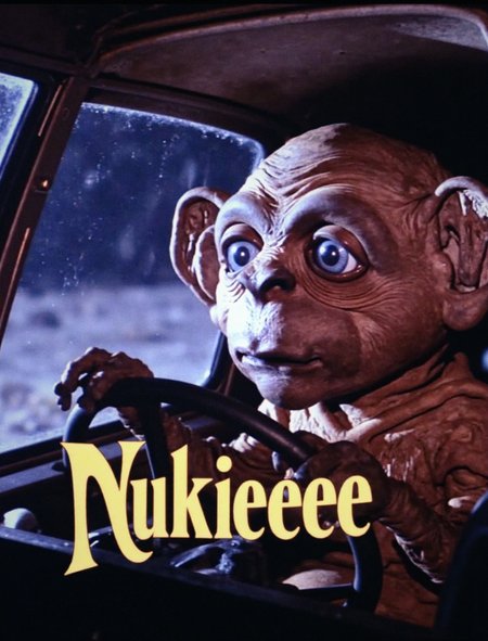A close-up photo where Nukie the knockoff alien appears stoned in the cockpit, cruising through space, with an overlayed radical 1980s style logo with "Nukieeeeee" across it.