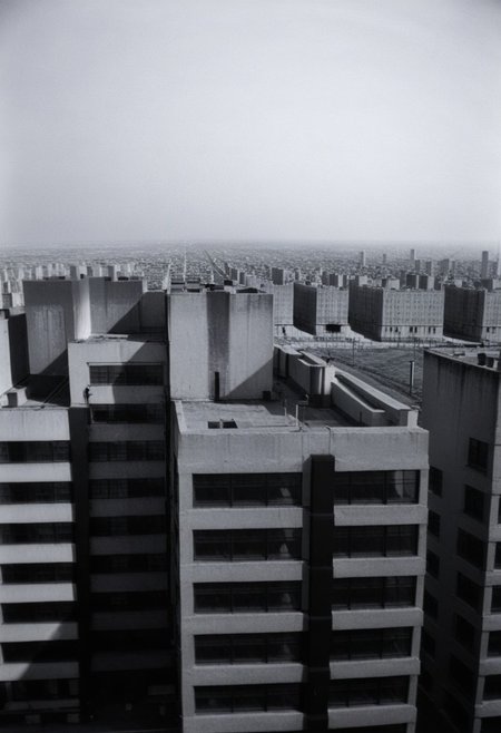 80sc1nemat1c5tyle, creamy bokeh, never ending line of buildings far away to the horizon, oppression, monochrome