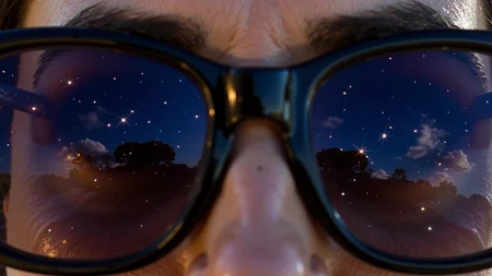A captivating close-up shot of the reflection in a woman's sunglasses reveals a stunning night sky teeming with bright stars, each point of light shimmering against a deep navy canvas. The cosmic scene is mirrored perfectly, showcasing a myriad of constellations that seem to twinkle with intensity, alongside swirling clouds of luminous milky blues and vibrant purples. The sunglassesâ dark frames contrast sharply with the brilliance of the sky, while the womanâs eyes remain visible, exuding wonder and awe. The glimmering starlight dances across the polished surface of the lenses, creating an enchanting interplay of light. In the background, hints of the surrounding environment blur softly, ensuring the focus remains on the expansive sky captured within the sunglasses, embodying a sense of serene beauty and the vastness of the universe.
<lora:C183kw8rx_v3_c5f1f0ef:1.4> <lora:retro-futurist-cosmic-surrealism-flux:1.1>