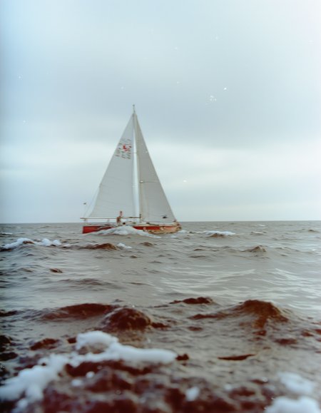 c41_hasselblad_portra400_FLUX, instagram photo of a sailboat in heavy sea, film grain, soft shadows