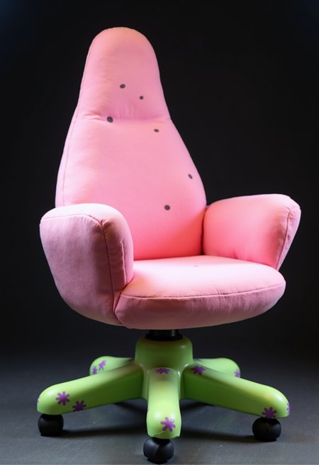 Patrick Star-inspired gaming chair, centered on a dark background. The chair takes on a soft, rounded shape, mimicking Patrick’s plump and starfish-like form. It’s covered in a smooth, plush pink material with subtle darker pink spots scattered across the surface. The seat and backrest are slightly curved, designed for maximum comfort, resembling Patrick’s laid-back nature.
The armrests are thick and rounded, shaped like Patrick’s stubby arms, extending outward in a relaxed manner. The base features five sturdy legs, colored in a vibrant green with a playful purple floral pattern, resembling his iconic swim trunks. The wheels are small, rounded, and slightly wobbly, giving the chair a fun, cartoonish personality. The overall atmosphere is cheerful, goofy, and perfectly suited for a gamer who embraces a carefree, fun-loving vibe.