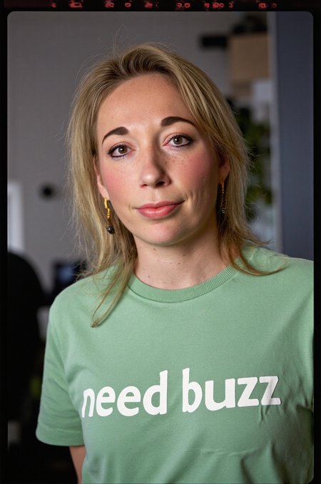 <lora:Ingrid Coenradie:1.6> Ingrid Coenradie , shirt, text that says "need buzz", RAW candid cinema, 16mm, color graded portra 400 film, remarkable color, ultra realistic, textured skin, remarkable detailed pupils, realistic dull skin noise, visible skin detail, skin fuzz, dry skin, shot with cinematic camera