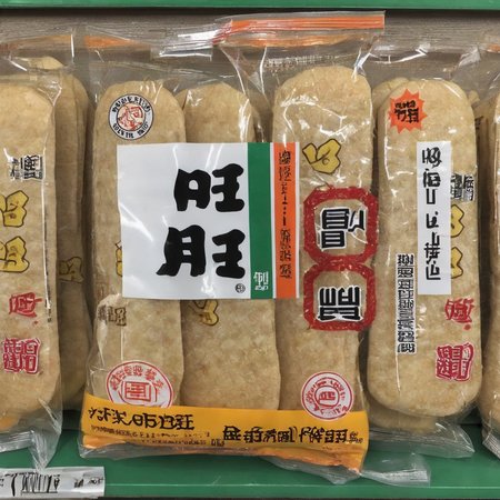 A table filled with packets of senbei (Japanese rice crackers). Each packet is clearly visible, showcasing the packaging design, especially the text and branding. The scene should be as realistic as a high-resolution photograph, with emphasis on the clarity and sharpness of the packet's text and design. The lighting should be even and bright, ensuring that every detail on the senbei packets is highlighted and easily discernible,  <lora:senbei:0.7>