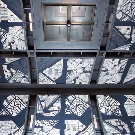 *A futuristic, cubic room where every surface—the floor, walls, and ceiling—looks identical, creating a symmetrical and disorienting space. The room is made of metallic panels, each featuring intricate, geometric patterns resembling advanced circuitry. These patterns are precisely cut into the metal, allowing a soft, white light to filter through, casting sharp, complex shadows across the surfaces. The cold, white light gives the room a sterile, almost otherworldly feel. The metallic surfaces subtly reflect the light and patterns, amplifying the sense of depth and making it difficult to distinguish one wall from another.
In the center of each of the six surfaces, including the floor and ceiling, is a square metallic door, seamlessly integrated into the surrounding panels. These doors are identical and blend into the room’s design, adding to the disorienting and claustrophobic atmosphere. The uniformity and symmetry of the room create a high-tech, sterile environment that feels isolating and mysterious.
The overall ambiance is one of eerie sophistication, blending advanced technology with unsettling uniformity. The space feels like a confining, enigmatic environment where every direction is the same, leaving anyone inside with a sense of isolation and uncertainty. Each surface of the room looks exactly the same. The room is 5 meters long in each direction.*