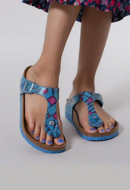 1girl, solo, dynamic_pose, simple_background, white_background, gizehonfeet, blue_toenail_polish, close-up, lower_body, footwear_focus, patterned, long_skirt