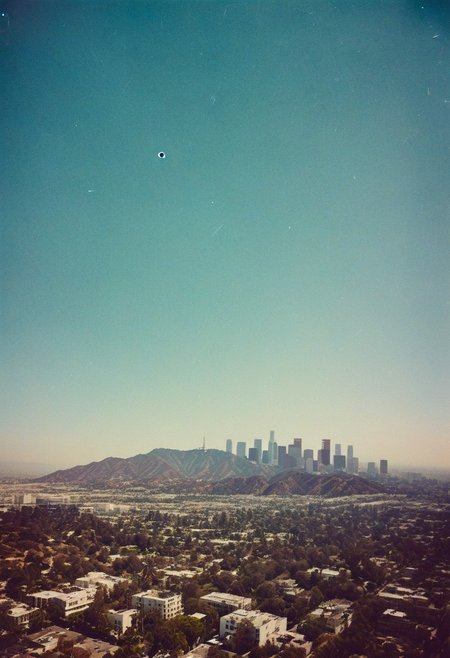 ()Hyoer Realistic:2.0)Polaroid picture 
an image of 
A stunning aerial view of Los Angeles, California, with a beautiful blue sky and palm trees lining the streets. The iconic Hollywood sign is visible on a hill, and the city skyline is dotted with modern skyscrapers and older buildings. The streets are bustling with life, and there's a sense of excitement and glamour in the air.