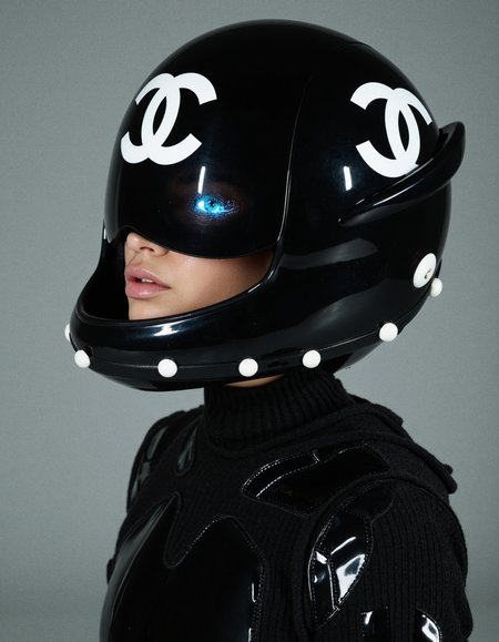  A surreal and imaginative fashion portrait depicting a model as a futuristic warrior, her face framed by a Chanel helmet adorned with pearls, blending elements of luxury fashion with sci-fi aesthetics in a visually arresting and conceptually layered narrative. Subject: In this completely random and imaginative portrait, the subject is envisioned as a futuristic warrior, her presence both commanding and ethereal. She is depicted wearing a sleek, black Chanel helmet that serves as both a fashion statement and a piece of high-tech armor. The helmet is crafted from a glossy, black material that reflects the light with a mirror-like sheen, giving it a futuristic, almost otherworldly appearance. The helmet is adorned with a large, glowing Chanel logo at the crown, which emits a soft, pulsating light, further enhancing the sci-fi aesthetic. The edges of the helmet are lined with large, luminous pearls that pulse with an internal light, adding a touch of luxury and femininity to the otherwise stark and utilitarian design. The pearls seem to float around the helmet, creating a halo effect that adds to the model’s divine and otherworldly aura. Beneath the helmet, the model’s face is partially visible, her eyes glowing with an unnatural, neon blue light that contrasts sharply with the dark helmet. Her eyes are framed by thick, cybernetic lashes that flicker with light, adding a touch of high-tech glamour to her intense gaze. The skin around her eyes is smooth and flawless, with a metallic sheen that hints at her futuristic, almost cyborg-like nature. A small, glowing Chanel logo is subtly integrated into her left cheek, serving as both a fashion statement and a high-tech branding mark. Her lips are painted in a deep, metallic shade, their smooth, reflective surface catching the light and giving her a slightly otherworldly, seductive expression. Her outfit is a black, armored suit that combines elements of high fashion with futuristic technology. The suit is made from a high-tech, flexible material that hugs her frame, with sections of reinforced armor plates that protect her vital areas. The suit is adorned with glowing, neon lines that trace the contours of her body, adding a dynamic, almost animated quality to her appearance. Around her neck, she wears a gold Chanel necklace that seems to float above her skin, the large, interlocking C’s glowing with an internal light that matches the neon lines of her suit. Lighting and Composition: The lighting in this surreal portrait is dramatic and dynamic, with a mix of soft, glowing light sources that highlight the textures and details of the helmet, pearls, and cybernetic enhancements. The light sources seem to emanate from within the helmet and suit, casting soft, colorful glows on her skin and creating a sense of depth and movement. The background is a dark, nebulous void, filled with swirling lights and abstract shapes that add to the otherworldly atmosphere of the image. The composition is tightly framed, focusing entirely on the model’s face and upper torso, with the glowing elements of the outfit creating a sense of energy and motion. The camera angle is slightly tilted, adding to the surreal, disorienting effect of the image. Overall Impression: This completely random and imaginative portrait is a bold and provocative exploration of the intersection between luxury fashion and futuristic technology, creating a visually arresting image that challenges traditional notions of identity, power, and beauty. The combination of the sleek, black Chanel helmet with the glowing, high-tech elements and the surreal, otherworldly background creates a powerful contrast that invites the viewer to contemplate the complexities of modern identity in a rapidly changing world. The meticulous attention to detail, from the glowing neon lines to the floating pearls, adds a layer of sophistication and innovation to the image, making it both visually captivating and conceptually rich. Key Focus: The fusion of futuristic technology, luxury fashion, and surreal, otherworldly elements creates a visually stunning and conceptually layered portrait that explores themes of identity, power, and the complexities of modern existence. 