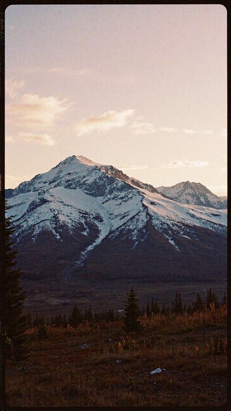 8n8log, Evening photo of an Alaskan mountainscape. Evening, long shadows, dusk <lora:GrainScape_1404698:1> , film photography aesthetic, film grain effect prominent throughout image, grainy film-like textureâââ