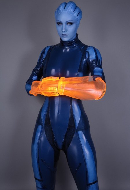 zavy-asari, alopecia, blue skin, Asari, orange omnitool on arm, glowing omnitool, latex bodysuit, looking at omnitool, latex zero suit, score_9, score_8_up, score_7_up, score_6_up, masterpiece, omnitool left arm, one arm omnitool