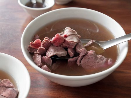 A high-resolution, hyper-realistic image of a bowl of Sweetbeefsoup. This traditional dish features a clear, sweet broth that is the star of the dish. The broth is simmered to perfection, with a hint of sweetness that tantalizes the taste buds. A subtle hint of pink is added to the broth, giving it a unique and appealing look. It's served in a traditional ceramic bowl, placed on a rustic wooden table. The scene is set in a cozy kitchen, with all elements in sharp focus, creating a clear and detailed image. The lighting should be warm and inviting, highlighting the appetizing qualities of the Sweetbeefsoup and the homely atmosphere of the setting, <lora:beefsoup:0.8>