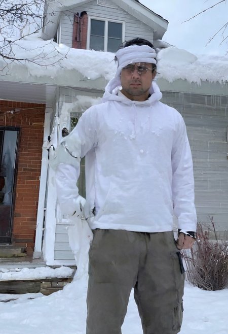 Stable_Yogis_SD1.5_Positives, patherpcook Stands in front of a House, Male, Strong, Flexing, Snow on head, Toga, Pondering, White house, Siding, walkway, driveway,