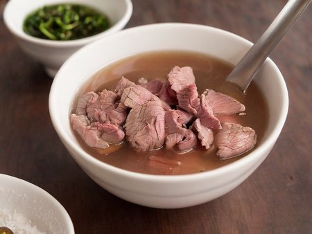A high-resolution, hyper-realistic image of a bowl of Sweetbeefsoup. This traditional dish features a clear, sweet broth that is the star of the dish. The broth is simmered to perfection, with a hint of sweetness that tantalizes the taste buds. A subtle hint of pink is added to the broth, giving it a unique and appealing look. It's served in a traditional ceramic bowl, placed on a rustic wooden table. The scene is set in a cozy kitchen, with all elements in sharp focus, creating a clear and detailed image. The lighting should be warm and inviting, highlighting the appetizing qualities of the Sweetbeefsoup and the homely atmosphere of the setting, <lora:beefsoup:0.8>