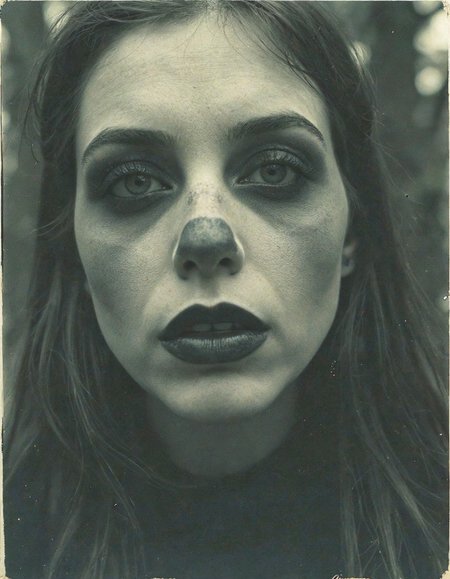 Vintage photo of an eerie portrait, the face is obscured by motion blur, in black and white with hints of dark green, set against a forest backdrop, evoking mystery and gothic vibes.
