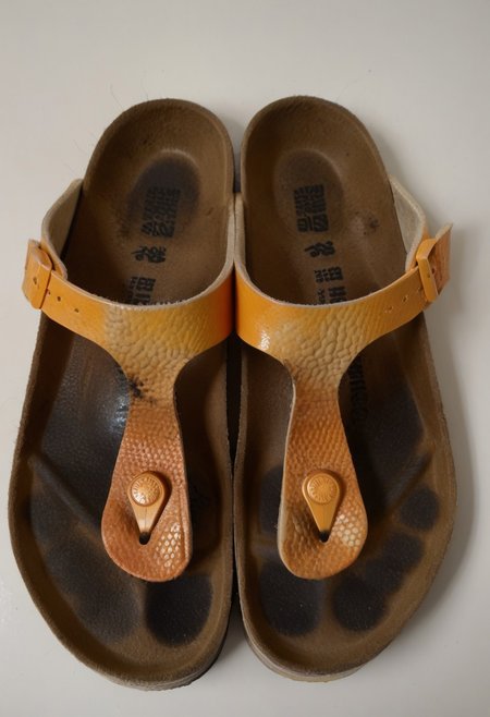 still_life, no_humans, simple_background, white_background, gizeh, gizehunworn, close-up, footwear_focus, patterned, orange-black-white, worn_shoes, worn_insoles, smelly_shoes