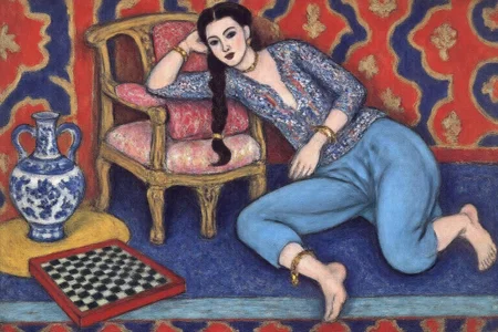 henrimatisse1 painting. 
A woman dressed in traditional attire, sitting on the floor with one leg bent and the other stretched out. She is wearing a blue outfit with intricate patterns and is adorned with bracelets. Her hair is styled in braids, and she appears relaxed, leaning against a chair. The chair is ornate, with a wooden frame and a cushion. To her left, a chessboard lies on the floor. Behind her, a vibrant, patterned background with red, blue, and gold designs. A large blue and white vase is also visible on the floor to her left.  <lora:henrimatisse1_f16e11:1.0><lora:870760665910914297:0>