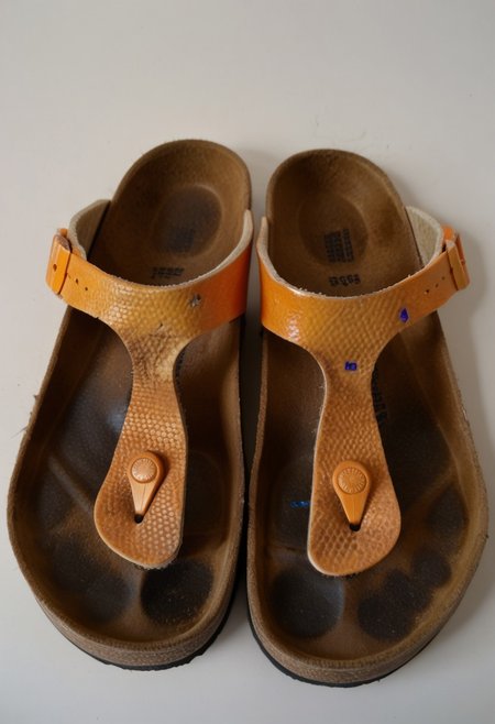 still_life, no_humans, simple_background, white_background, gizeh, gizehunworn, close-up, footwear_focus, patterned, orange-black-white, worn_shoes, worn_insoles, smelly_shoes