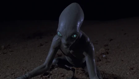 cinematic close-up shot of a grey alien crouching in the desert at night. Cold harsh artificial light coming from above as a cone and reflecting off its skin. High resolution. 1990s movie <lora:dark_cinematic-000080:1>