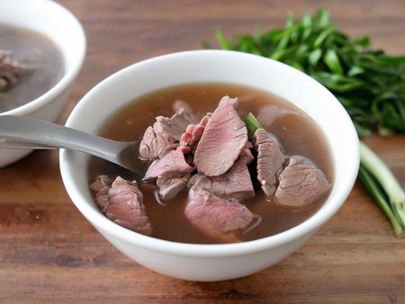 A high-resolution, hyper-realistic image of a bowl of Sweetbeefsoup. This traditional dish features a clear, sweet broth that is the star of the dish. The broth is simmered to perfection, with a hint of sweetness that tantalizes the taste buds. A subtle hint of pink is added to the broth, giving it a unique and appealing look. The soup is garnished with fresh ginger and scallions, which are evenly sprinkled throughout the broth, adding a pop of color and enhancing the flavor. It's served in a traditional ceramic bowl, placed on a rustic wooden table. The scene is set in a cozy kitchen, with all elements in sharp focus, creating a clear and detailed image. The lighting should be warm and inviting, highlighting the appetizing qualities of the Sweetbeefsoup and the homely atmosphere of the setting,<lora:beefsoup:0.75>