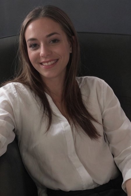 30yo American woman wearing bussiness suit holding a cigarrete
Dark black smooth long hair ponytail. smiling.
Looking at camera.
Dynamic varying pose.
Outside bussiness. Night time,  
Night time, dark.