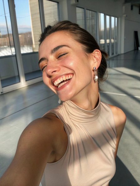 A elegant Bulgarian model with cool undertones shines under soft , directional window light. She snaps a selfie mid-laugh , her hazel eyes crinkling warmly. Her sleek smoky quartz colored cowl neck top that shows D cup chest fuller bustline size with 10 lbs weight, while silver stud earrings add subtle edge. The image captures her skin’s natural texture, with wrinkled skin and an unfiltered , authentic glow . Foreground: Sharp focus on her playful expression and glowing complexion . The light catches a faint reflection in her eyes, mimicking distant city lights . Middle Ground: She leans forward , her blouse slipping slightly off one shoulder. The satin bralette reflects muted highlights , contrasting with the textured backdrop . Background: A minimalist loft with floor-to-ceiling windows framing a misty metropolis at dusk. Raindrops streak the glass, blending with the soft glow of skyscraper lights . A vintage brass floor lamp emits warm light , casting geometric shadows.