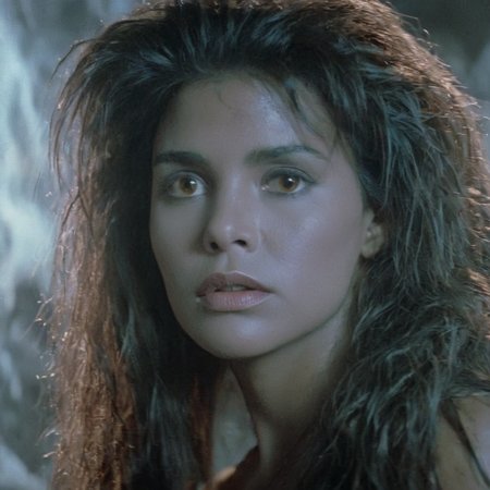 Horror-themed,  <lora:Fright Night 1985 Film Style:1>
Cinematic Closeup Shot Film Footage captured by Panavision Cameras, Regine Dandridge a sexy white cave woman with long messy hair and an innocent look on her face staring at someone to the left with cool light onFright Night 1985 Film Style, Eerie, unsettling, dark, spooky, suspenseful, grim, highly detailed