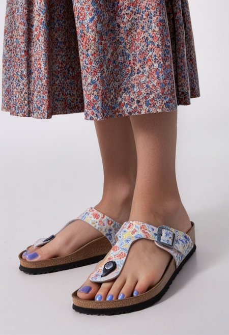 1girl, solo, simple_background, white_background, gizehonfeet, blue_toenail_polish, close-up, lower_body, footwear_focus, patterned, long_skirt