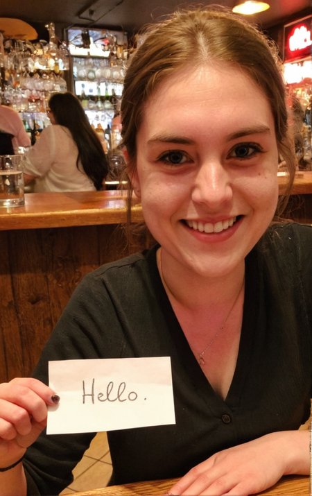 badquality, low quality, amateur photography <lora:badquality_v02:0.8>,  <lora:text_lora:0.2> In  a bar a woman holding piece of paper with handwritten text 'hello'