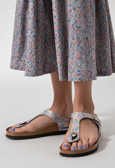 1girl, solo, simple_background, white_background, gizehonfeet, blue_toenail_polish, close-up, lower_body, footwear_focus, patterned, long_skirt
