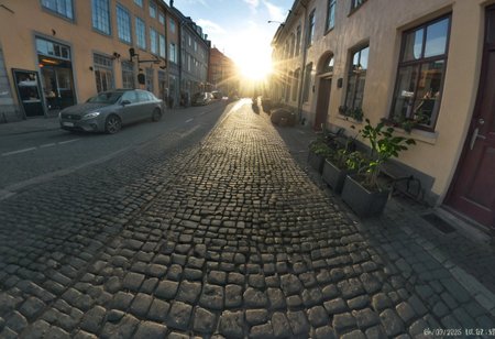 randshadscree, photograph, evening, sunshine, backlit, lens flare, fish eye, dutch angle, lens flare, silhouette,
bus,
old town, scandinavian, cobblestone, potted plants, partially cloudy,