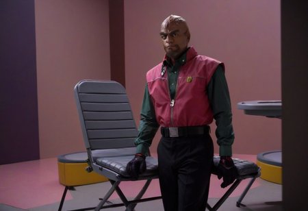 cinematic film still, 
saturated colors, 
negative space, 
 1 adult man, (breaking bad style), (solo male focus), looking at viewer, face of Gustavo Fring, dark skinned, dark hair, short hair,
employee uniform,pink and red shirt, Black slack pants with yellow stripes,  red visor cap with "W" logo, Socks with the "w" logo, loafers
, folding chairs, sitting on chairs,
 smile


framing device, negative space, leading lines, 
backdrop is a cybernetic interior of a space base