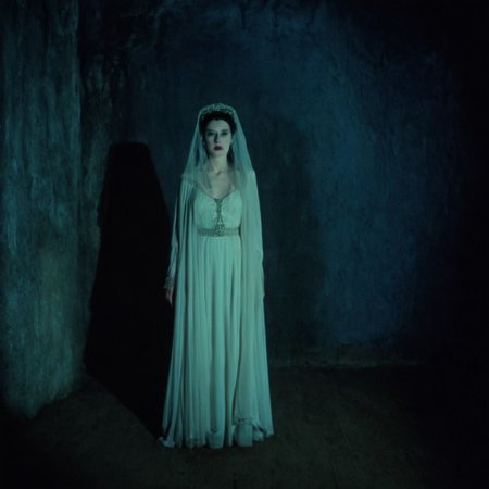 cinematic film still of  <lora:brides of dracula style:1>
full shot, wide shot, 15th-century 1897 a  60yo old lady  woman in a white dress and a veil posing for a picture in a dark studio room with dark blue grey background Kodak Eastman EXR 50D 5245, EXR 500T 5296 Cinematic Film in a scene from the brides of dracula style, shallow depth of field, vignette, highly detailed, high budget, bokeh, cinemascope, moody, epic, gorgeous, film grain, grainy