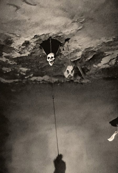 antique photo, eerie atmosphere, creepy, cave, descent into madness, lovecraft horror, walls made of skulls, one bat hanging from the ceiling, <lora:Antique_Photo:1>