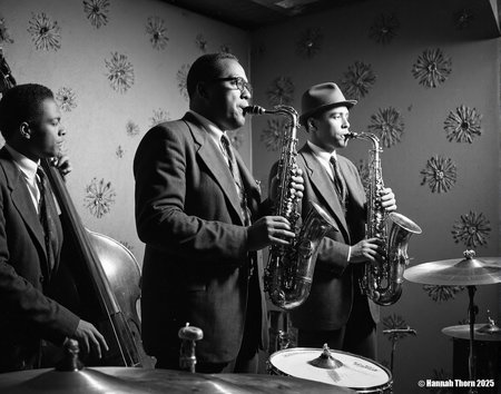 The image is a black and white photograph depicting a jazz band in performance.    **Description:**  The photo shows three musicians prominently featured. The central figure is a man playing a tenor saxophone; he's wearing a dark suit and tie. To his right, another man in a suit and fedora plays an alto saxophone. On the left, partially obscured, a third musician is visible, playing a double bass. The background is a dimly lit room with indistinct wall décor that suggests a jazz club setting.  There are drums partially visible in the foreground, along with cymbals. The lighting is dramatic, focusing primarily on the saxophonists, with the rest of the scene falling into shadow. The overall mood is one of intense concentration and musical energy.   **Style:**  The photograph's style is classic black and white photojournalism or fine art photography, characteristic of mid-20th-century jazz photography.  The use of high contrast, deep shadows, and a focus on the musicians' expressive faces and hands creates a sense of intimacy and immediacy. The grainy texture of the image, which is probably intentional, adds to the vintage feel and emphasizes the mood of the scene. The composition is relatively candid, with the musicians seemingly caught in the moment of performance rather than posed formally.  The use of light and shadow helps draw the viewer's eye to the central musicians and instruments. <lora:_Flux\Vintage_Jazz-Club.safetensors:1.0:1.0>