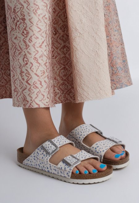 1girl, solo, simple_background, white_background, birksonfeet, blue_toenail_polish, close-up, lower_body, footwear_focus, patterned, long_skirt